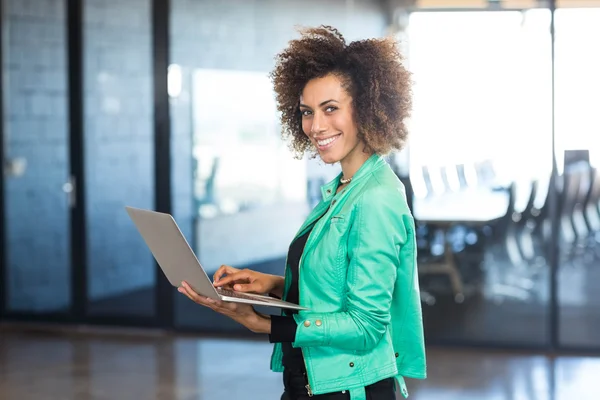 Jovem mulher usando laptop no escritório — Fotografia de Stock