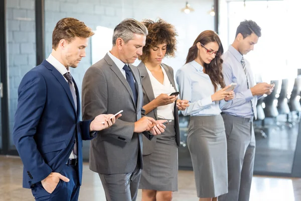 Equipo de negocios usando teléfono móvil — Foto de Stock