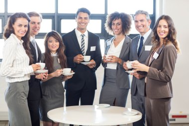 Businesspeople standing together in office clipart
