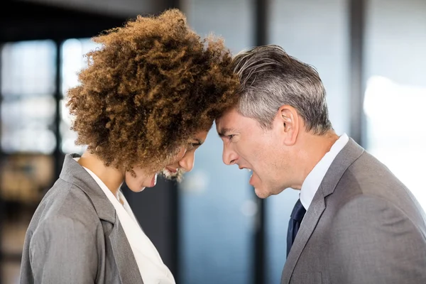 Angry businesspeople standing head to head — Stock Photo, Image