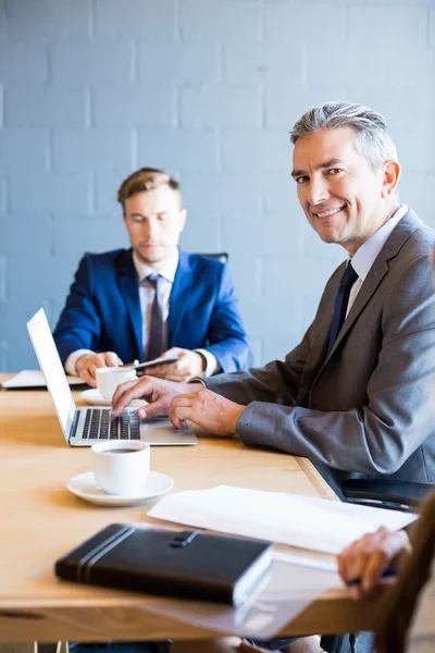 Empresário trabalhando no laptop em reunião — Fotografia de Stock