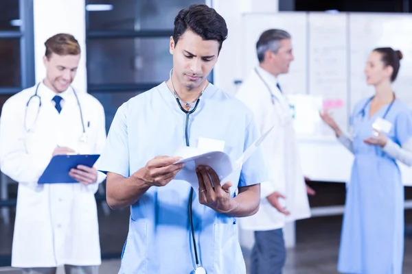 Médico que verifica o relatório médico — Fotografia de Stock