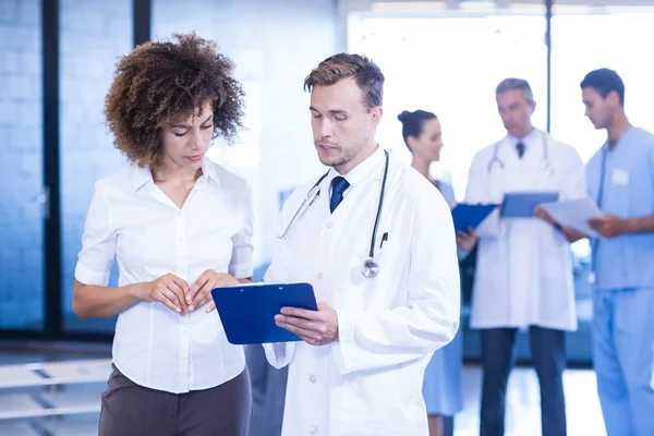 Médico e colega olhando para o relatório médico — Fotografia de Stock