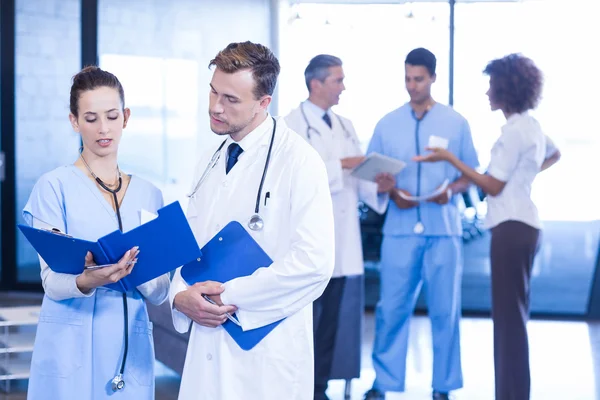 Doctors looking at medical report — Stock Photo, Image