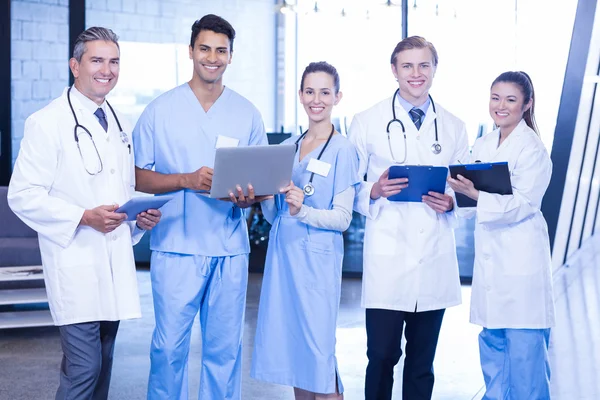 Médicos com tablet, laptop e relatório médico — Fotografia de Stock