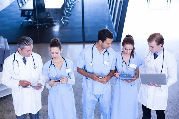 Медицинская команда с помощью ноутбука, мобильного телефона и планшета — стоковое фото