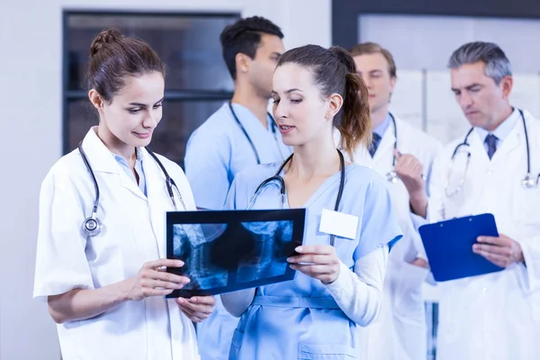 Female doctors checking x ray reports — Stock Photo, Image