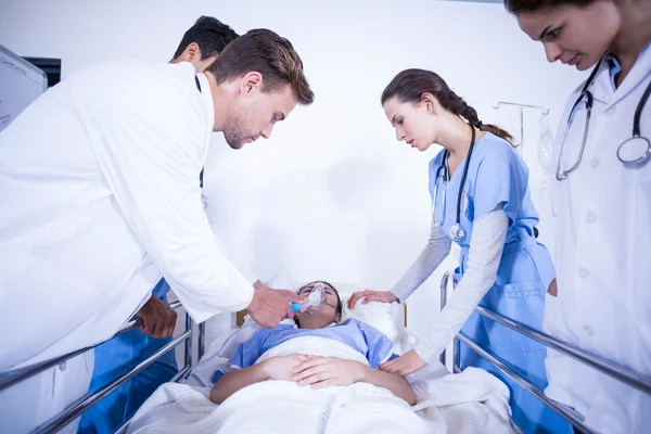 Läkare undersöker patienten på sängen — Stockfoto