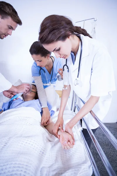 Ärzte untersuchen Patientin im Bett — Stockfoto