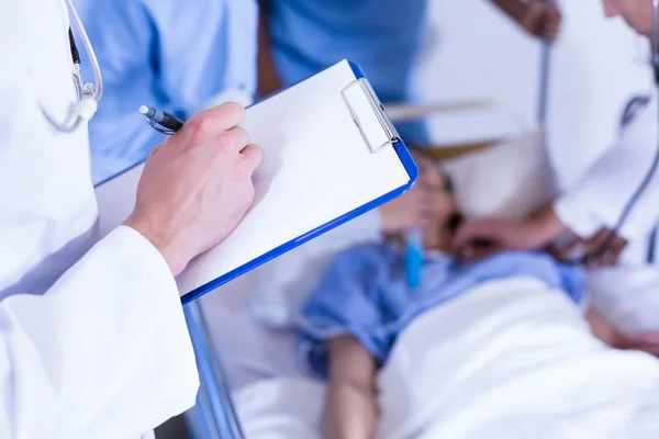 Médico escrevendo na área de transferência — Fotografia de Stock