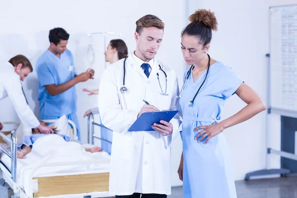 Doctors writing on clipboard — Stock Photo, Image