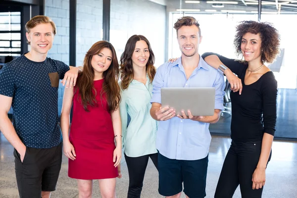 Kollegor hålla laptop och leende — Stockfoto