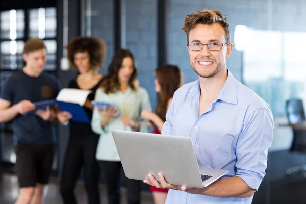 Mann hält Laptop in der Hand und lächelt — Stockfoto