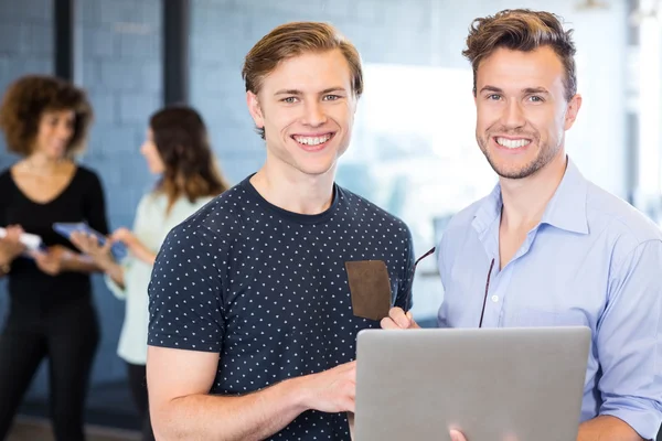 Männer halten Laptop in der Hand und lächeln — Stockfoto