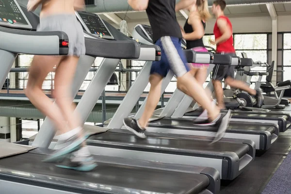 Mujeres y hombres corriendo en una cinta de correr — Foto de Stock