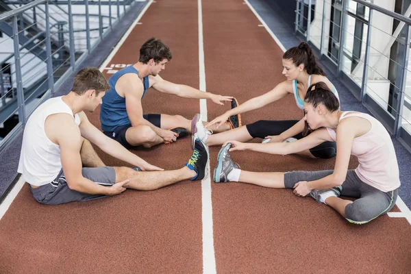 Atletische vrouwen en mannen die zich uitstrekt — Stockfoto