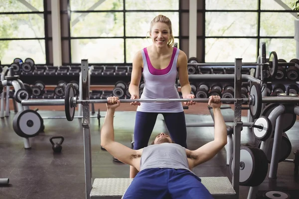 Trainer donna aiutare l'uomo atletico — Foto Stock