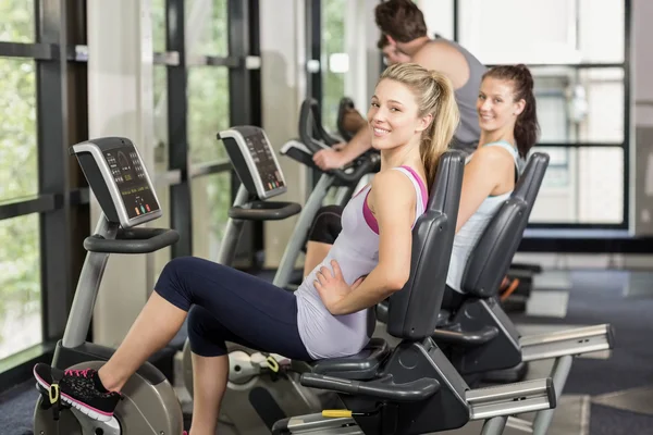 Fit people doing exercise bike — Stock Photo, Image