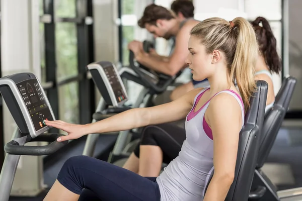 Fit people doing exercise bike — Stock Photo, Image