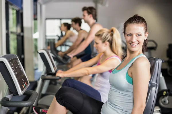 Fit people doing exercise bike — Stock Photo, Image