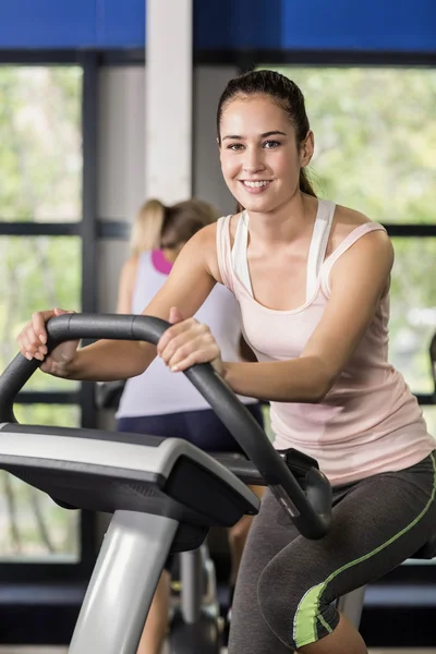 Vältränad kvinna gör motionscykel — Stockfoto