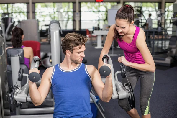 Trainer vrouw helpen atletische man — Stockfoto