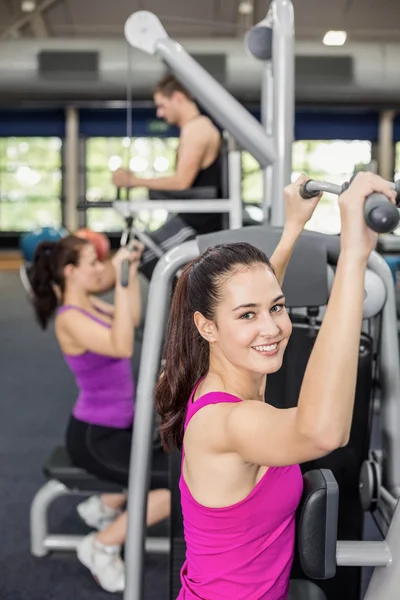 Fit mulher usando máquina de peso — Fotografia de Stock