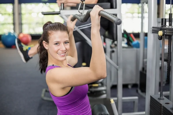 Fit woman using weight machine — Stock Photo, Image