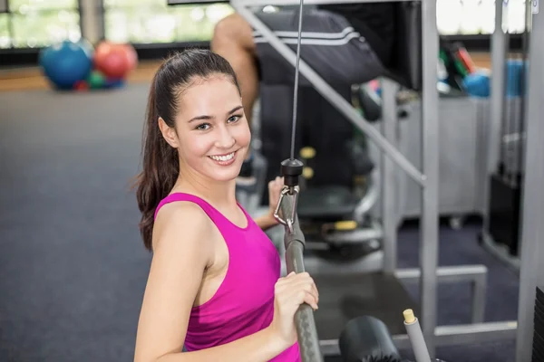 Fit mulher usando máquina de peso — Fotografia de Stock