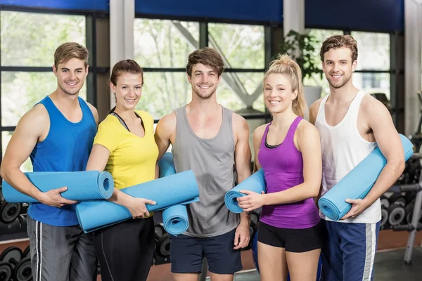 Menschen mit Fitnessmatte im Fitnessstudio — Stockfoto