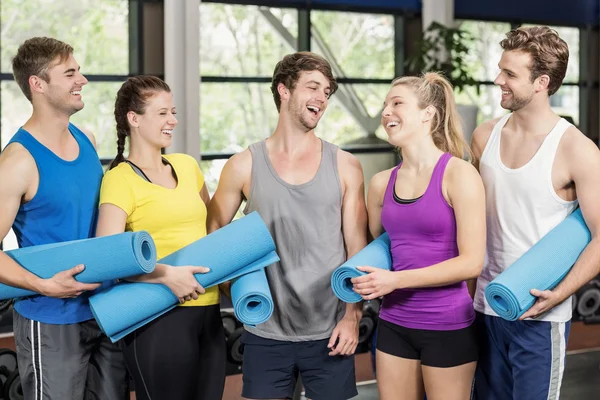 Menschen mit Fitnessmatte im Fitnessstudio — Stockfoto