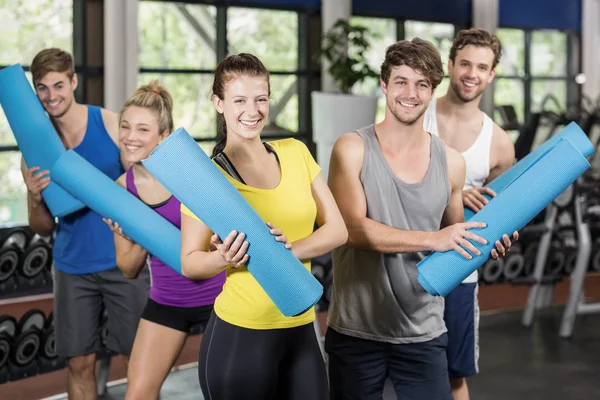 People with fitness mat in gym — Stock Photo, Image