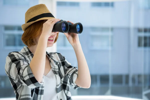Red haired hipster looking through binoculars — Stock Photo, Image