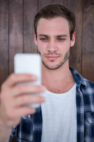 Hübscher Hipster schaut aufs Smartphone — Stockfoto