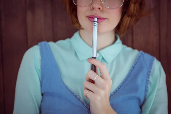 Red haired hipster chewing a pen — Stock Photo, Image