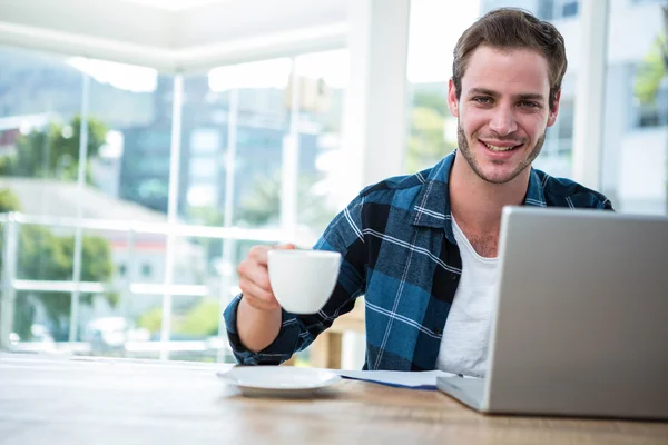 Man som arbetar på laptop med kopp kaffe — Stockfoto