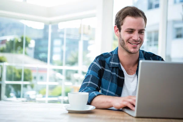 Homem trabalhando no laptop com xícara de café — Fotografia de Stock