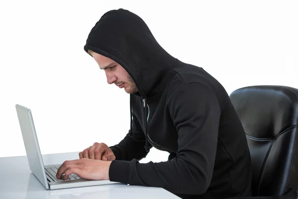 Homem de capuz preto usando laptop — Fotografia de Stock