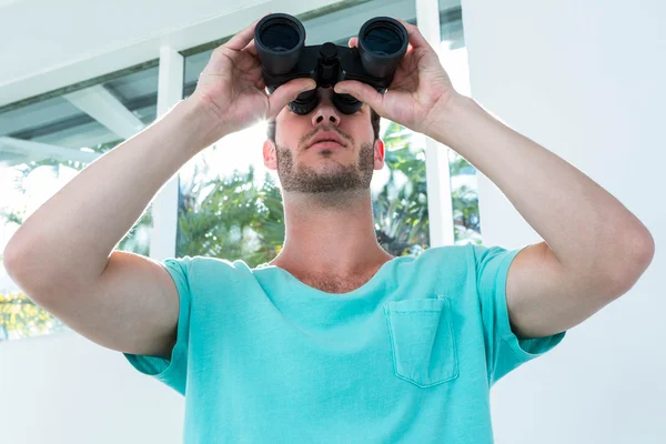 Hipster man looking through binoculars — Stock Photo, Image