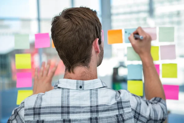 Hipster-Mann schreibt über Post-it — Stockfoto