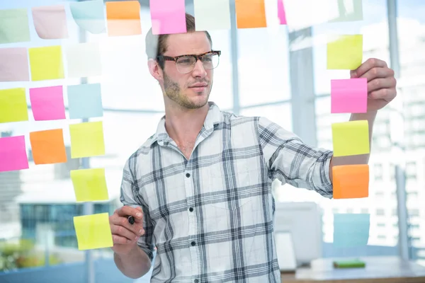 Hipster man looking at post-it — Stock Photo, Image