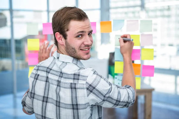 Hipster-Mann schreibt über Post-it — Stockfoto