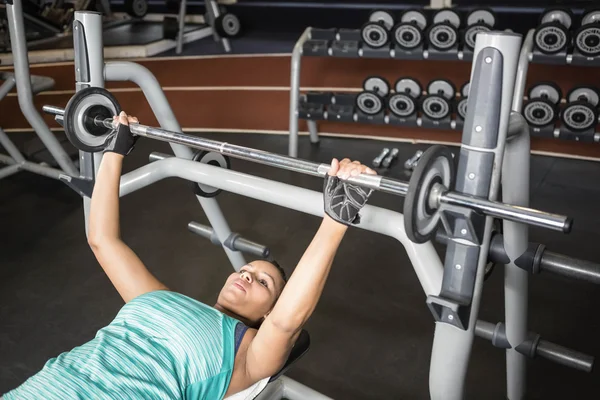 Woman using weight machine — Stockfoto