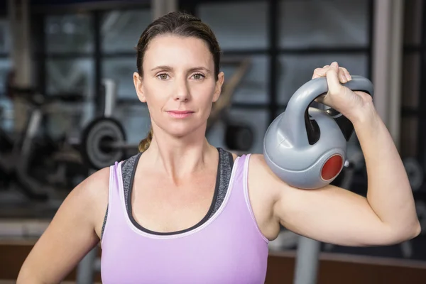 Woman holding heavy kettlebell — Stock Photo, Image