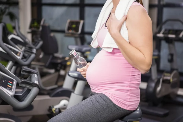 Kobieta w ciąży na rower treningowy — Zdjęcie stockowe