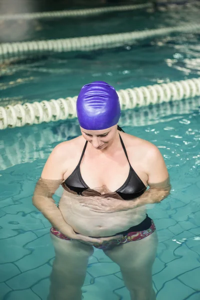 Mujer embarazada de pie en la piscina — Foto de Stock