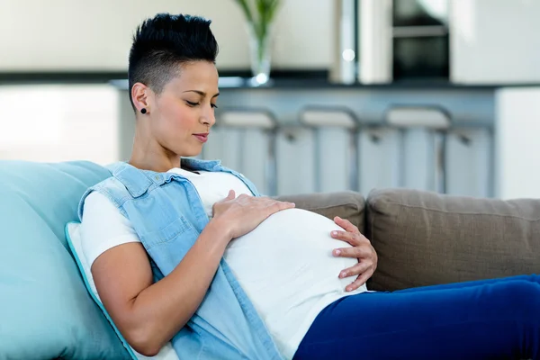 Donna incinta rilassante sul divano — Foto Stock