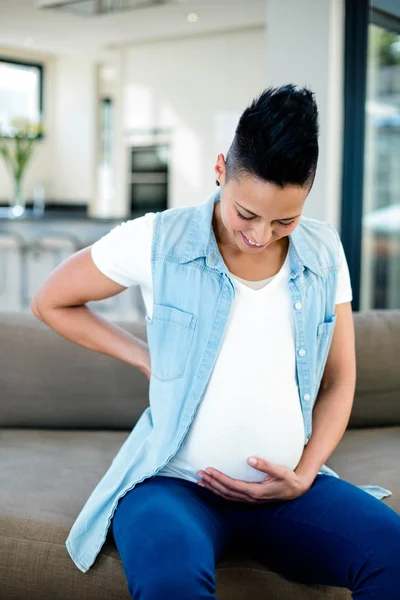 Schwangere Frau sitzt auf Sofa — Stockfoto