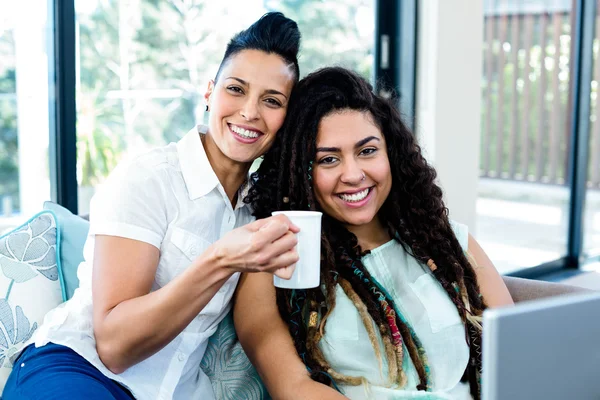 Pareja lesbiana tomando café y usando laptop — Foto de Stock