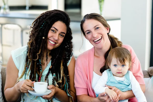 Kvinnor sitter på soffan med baby — Stockfoto